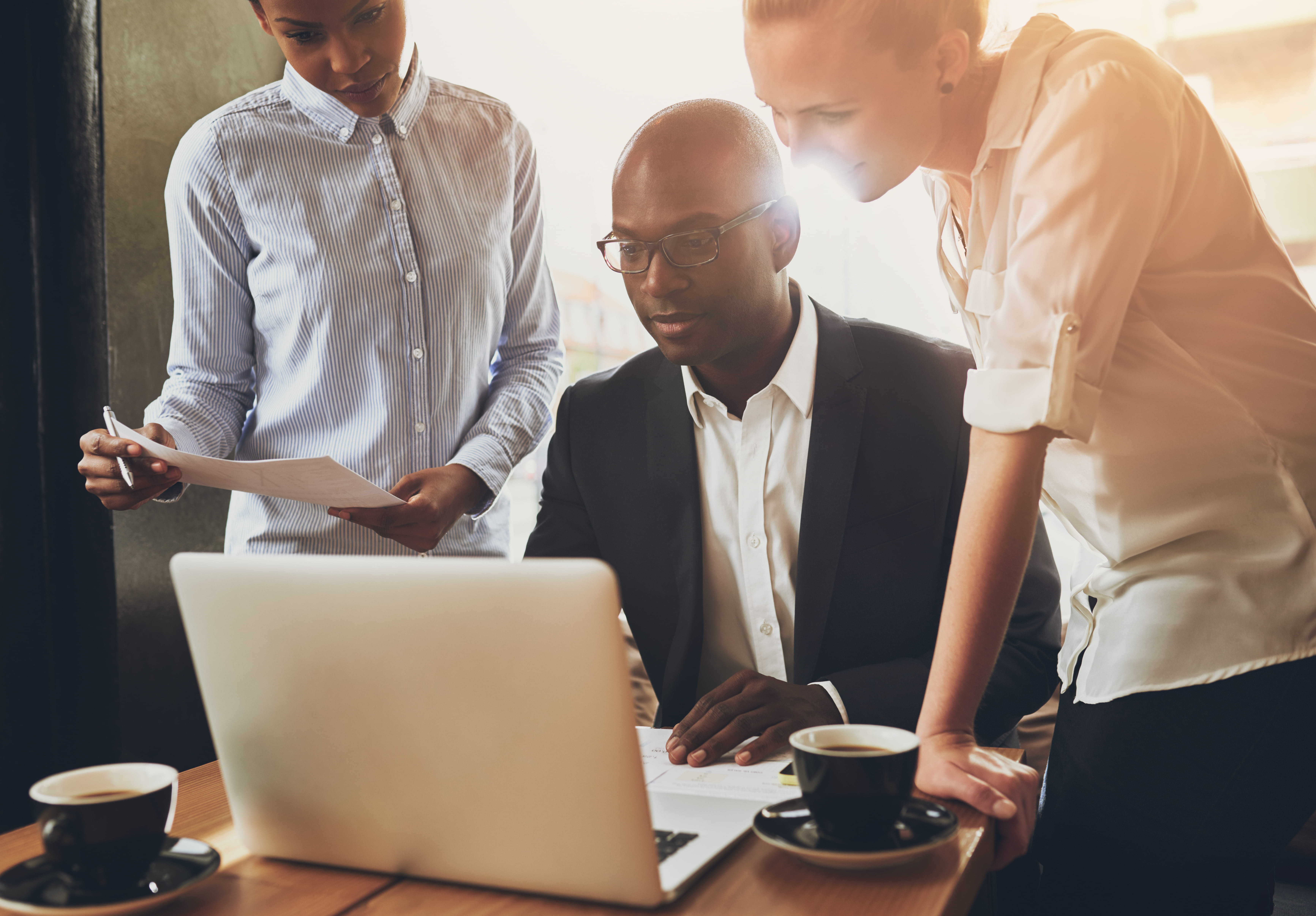 three professionals looking at laptop