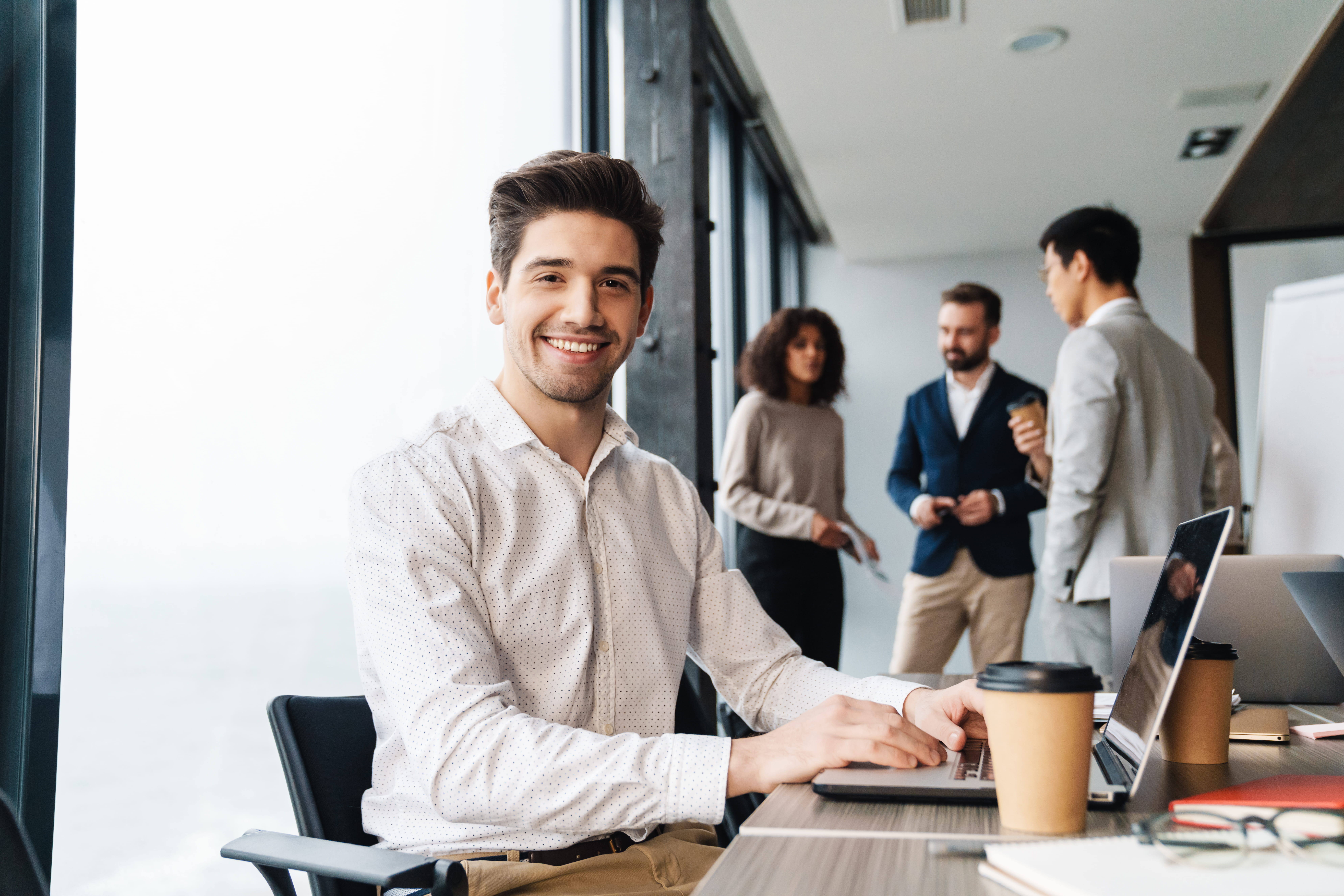 smiling man working on laptop