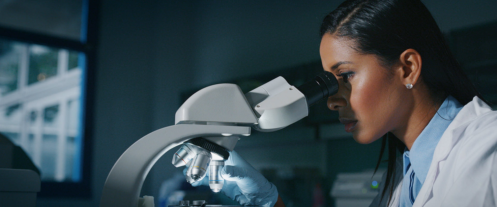 woman looking through microscope