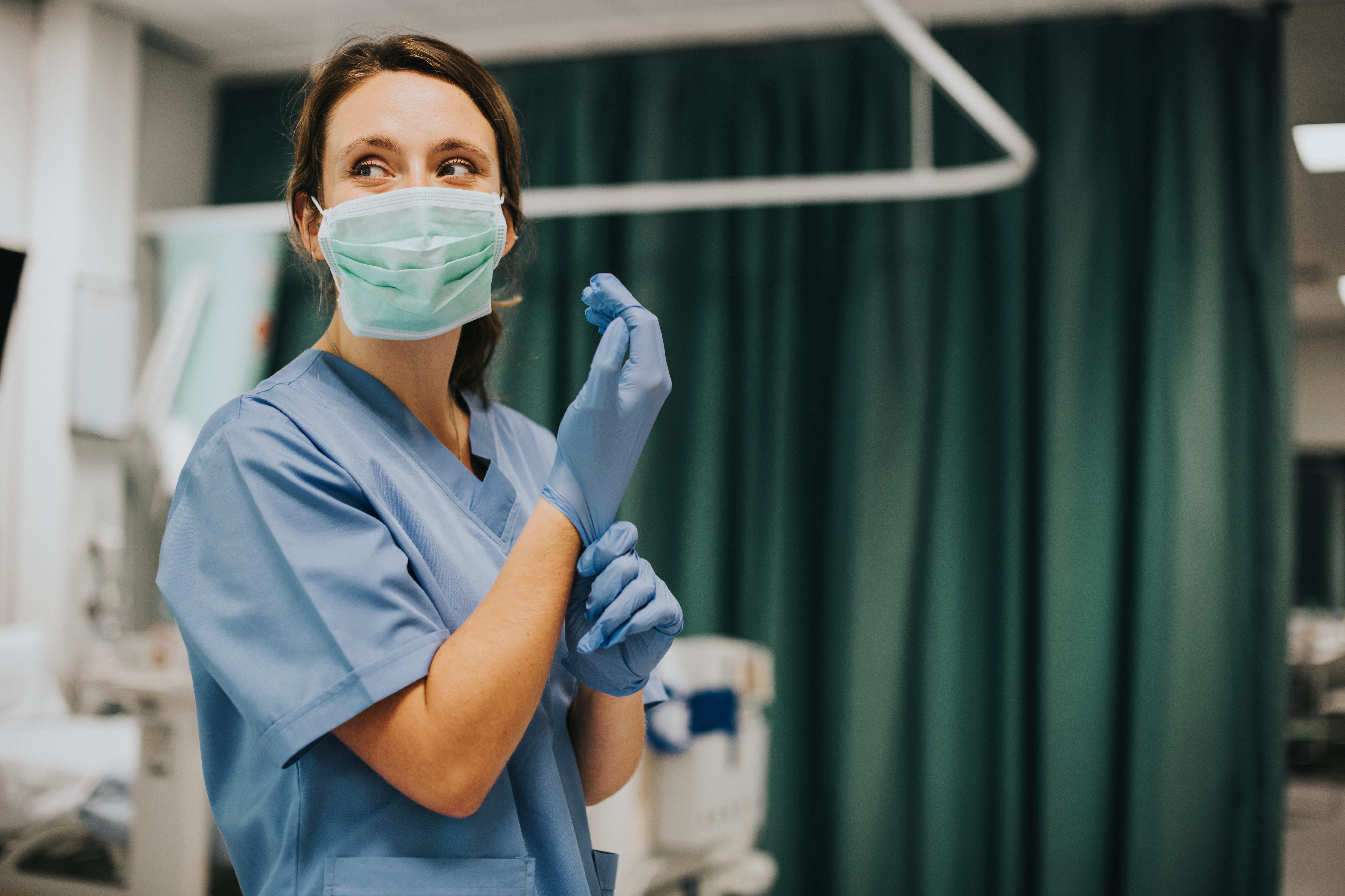 medical professional wearing scrubs mask and gloves