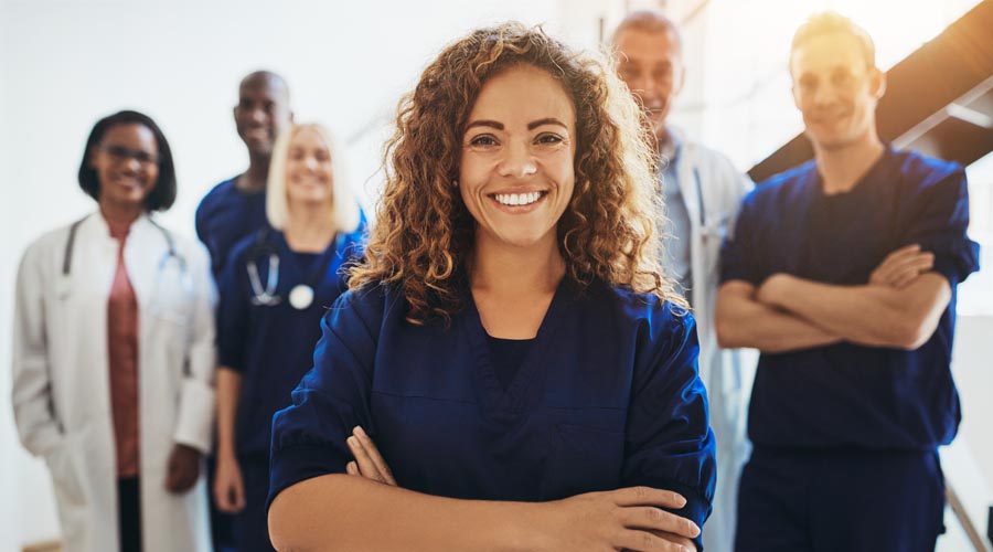 Confident female medical professional with arms crossed, smiling