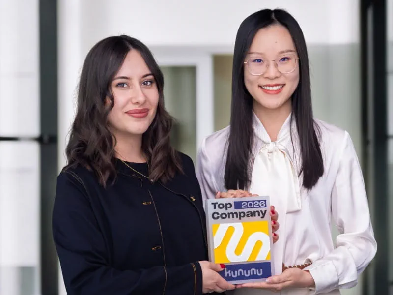 Zwei Mitarbeiterinnen halten den kununu Top Company 2026 Award